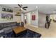 Comfortable living room featuring a plush sofa, ceiling fan, and decorative sports memorabilia at 3911 E Rockingham Rd, Phoenix, AZ 85050