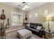 Comfortable living room with leather sofa, guitars, and natural light at 3911 E Rockingham Rd, Phoenix, AZ 85050