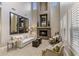 Spacious living room featuring tall ceilings, large mirrors, fireplace, and large windows at 3911 E Rockingham Rd, Phoenix, AZ 85050