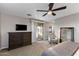 Spacious main bedroom with sliding glass doors, neutral tones, and a wooden dresser at 3911 E Rockingham Rd, Phoenix, AZ 85050