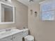 Cozy half bathroom featuring a modern vanity, toilet, decor, and window with coverings at 40613 N Jerlyn Pl, San Tan Valley, AZ 85140