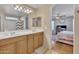 This full bathroom features double sinks, a large mirror and an adjacent bedroom at 40613 N Jerlyn Pl, San Tan Valley, AZ 85140