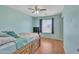 A bedroom with blue walls, wood floors, ceiling fan, window with blinds and blue curtains at 40613 N Jerlyn Pl, San Tan Valley, AZ 85140