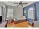 Bright bedroom with a blue accent wall, wood floors, and plenty of natural light at 40613 N Jerlyn Pl, San Tan Valley, AZ 85140