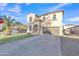 Inviting two-story home with a stucco exterior, arched doorway, and long driveway at 40613 N Jerlyn Pl, San Tan Valley, AZ 85140