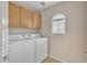 Functional laundry room featuring modern washer and dryer, storage, and natural light at 40613 N Jerlyn Pl, San Tan Valley, AZ 85140