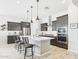 Modern kitchen with dark cabinets, stainless steel appliances, a spacious island, and pendant lighting at 4164 E Bernice St, Gilbert, AZ 85295