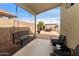 Cozy covered back patio with a swing bench and outdoor seating, perfect for relaxing outdoors at 42370 W Hillman Dr, Maricopa, AZ 85138