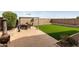 Well-maintained backyard with a gazebo, an artificial lawn, and a paved patio area at 42370 W Hillman Dr, Maricopa, AZ 85138