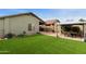 Backyard with green artificial turf, a gazebo with table & chairs, and a covered patio at 42370 W Hillman Dr, Maricopa, AZ 85138