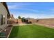 Wide backyard showing artificial turf lawn, gazebo, brick patio, and privacy wall at 42370 W Hillman Dr, Maricopa, AZ 85138