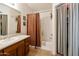 Bright bathroom featuring a shower-tub combo, vanity, and adjacent closet space at 42370 W Hillman Dr, Maricopa, AZ 85138