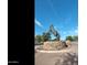 Striking statue of a rearing horse on a stone base in the community with blue sky at 42370 W Hillman Dr, Maricopa, AZ 85138