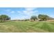 Picturesque golf course view with manicured green lawns, trees, and desert landscape at 42370 W Hillman Dr, Maricopa, AZ 85138