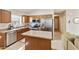 Kitchen with stainless appliances, wood cabinets, and breakfast bar at 42370 W Hillman Dr, Maricopa, AZ 85138