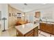 Functional kitchen featuring wood cabinetry, tile floors and dining space at 42370 W Hillman Dr, Maricopa, AZ 85138
