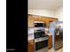 Well-equipped kitchen boasts stainless steel appliances, light wood cabinets, and a sleek electric range at 42370 W Hillman Dr, Maricopa, AZ 85138