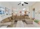 Open-concept living room featuring a neutral color palette, ceiling fan, and seamless transition to the kitchen and dining area at 42370 W Hillman Dr, Maricopa, AZ 85138