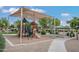 Community playground with shade canopy, play structures, seating area, and landscaped surroundings at 42370 W Hillman Dr, Maricopa, AZ 85138