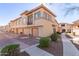 View of townhomes featuring private garages, patios, and well-maintained landscaping in a sunny neighborhood at 42424 N Gavilan Peak Pkwy # 63212, Anthem, AZ 85086