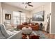 Cozy living room boasts stylish decor with a ceiling fan, leather couch, and unique ottoman at 42424 N Gavilan Peak Pkwy # 63212, Anthem, AZ 85086