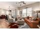 Bright living room with a ceiling fan, hardwood floors, and a comfortable leather couch at 42424 N Gavilan Peak Pkwy # 63212, Anthem, AZ 85086