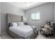 Cozy bedroom with a tufted headboard bed, chair, and large window at 45975 W Mountain View Rd, Maricopa, AZ 85139