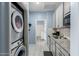 Bright kitchen featuring white appliances and gray cabinets, with a convenient washer and dryer located nearby at 45975 W Mountain View Rd, Maricopa, AZ 85139
