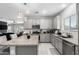 Open kitchen features stainless steel appliances, a central island, and sleek gray cabinets at 45975 W Mountain View Rd, Maricopa, AZ 85139