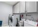 Well-equipped laundry room with a modern washer, dryer, storage cabinets, and a sink for added convenience at 45975 W Mountain View Rd, Maricopa, AZ 85139