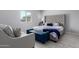 Comfortable bedroom featuring a large upholstered bed, storage bench and a window for natural light at 45975 W Mountain View Rd, Maricopa, AZ 85139