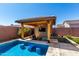 An outdoor kitchen with barstool seating overlooks a refreshing pool; perfect for entertaining or relaxing outdoors at 45975 W Mountain View Rd, Maricopa, AZ 85139
