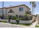 Inviting two-story stucco home with a tile roof, lush landscaping, and a charming wrought iron fenced in patio at 4927 E Hazel Dr # 2, Phoenix, AZ 85044