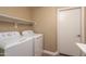 Functional laundry room featuring a washer, dryer, overhead shelving, and a utility door at 4927 E Hazel Dr # 2, Phoenix, AZ 85044