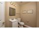 Powder room with decorative mirror, vanity, toilet, and wood-look flooring at 4927 E Hazel Dr # 2, Phoenix, AZ 85044