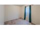 A basic bedroom with neutral walls and carpet, featuring a window with blinds and green curtains at 49853 W Jean Dr, Maricopa, AZ 85139