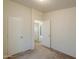 Empty bedroom with neutral carpet, white doors, and view of an adjacent room at 49853 W Jean Dr, Maricopa, AZ 85139