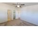 Bedroom featuring carpet, ceiling fan, closet and view of an adjacent bathroom at 49853 W Jean Dr, Maricopa, AZ 85139