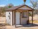 Charming small outbuilding with a covered porch, window, and a 'Whiskey Row' sign on the front at 49853 W Jean Dr, Maricopa, AZ 85139