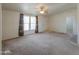 Spacious living room featuring neutral carpet, ceiling fan, and window at 49853 W Jean Dr, Maricopa, AZ 85139