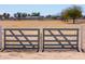 A gated property entrance offers an expansive view of the ranch property at 49853 W Jean Dr, Maricopa, AZ 85139