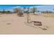 Vintage windmill and trough sit in a sandy yard under a blue sky at 49853 W Jean Dr, Maricopa, AZ 85139