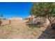 Backyard view with block fence, small covered patio, and some mature trees at 5057 E Dragoon Ave, Mesa, AZ 85206