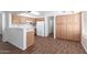 Bright kitchen with white appliances, wooden cabinets, breakfast bar and durable flooring at 5057 E Dragoon Ave, Mesa, AZ 85206