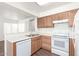 Well-lit kitchen featuring bright appliances, wood cabinets, and durable floors at 5057 E Dragoon Ave, Mesa, AZ 85206