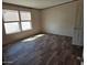 Bright bedroom with wood-look floors, two windows, and a closet at 52150 W Cardinal S Rd, Maricopa, AZ 85139