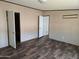 Bright bedroom featuring wood-look floors and a white closet door at 52150 W Cardinal S Rd, Maricopa, AZ 85139