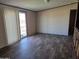 Living room with updated flooring and natural light from the sliding glass door at 52150 W Cardinal S Rd, Maricopa, AZ 85139