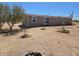 Wide shot of the back side of a house with minimal desert landscaping at 52150 W Cardinal S Rd, Maricopa, AZ 85139
