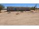 Wide shot of a single-story home with a back door and desert landscaping at 52150 W Cardinal S Rd, Maricopa, AZ 85139